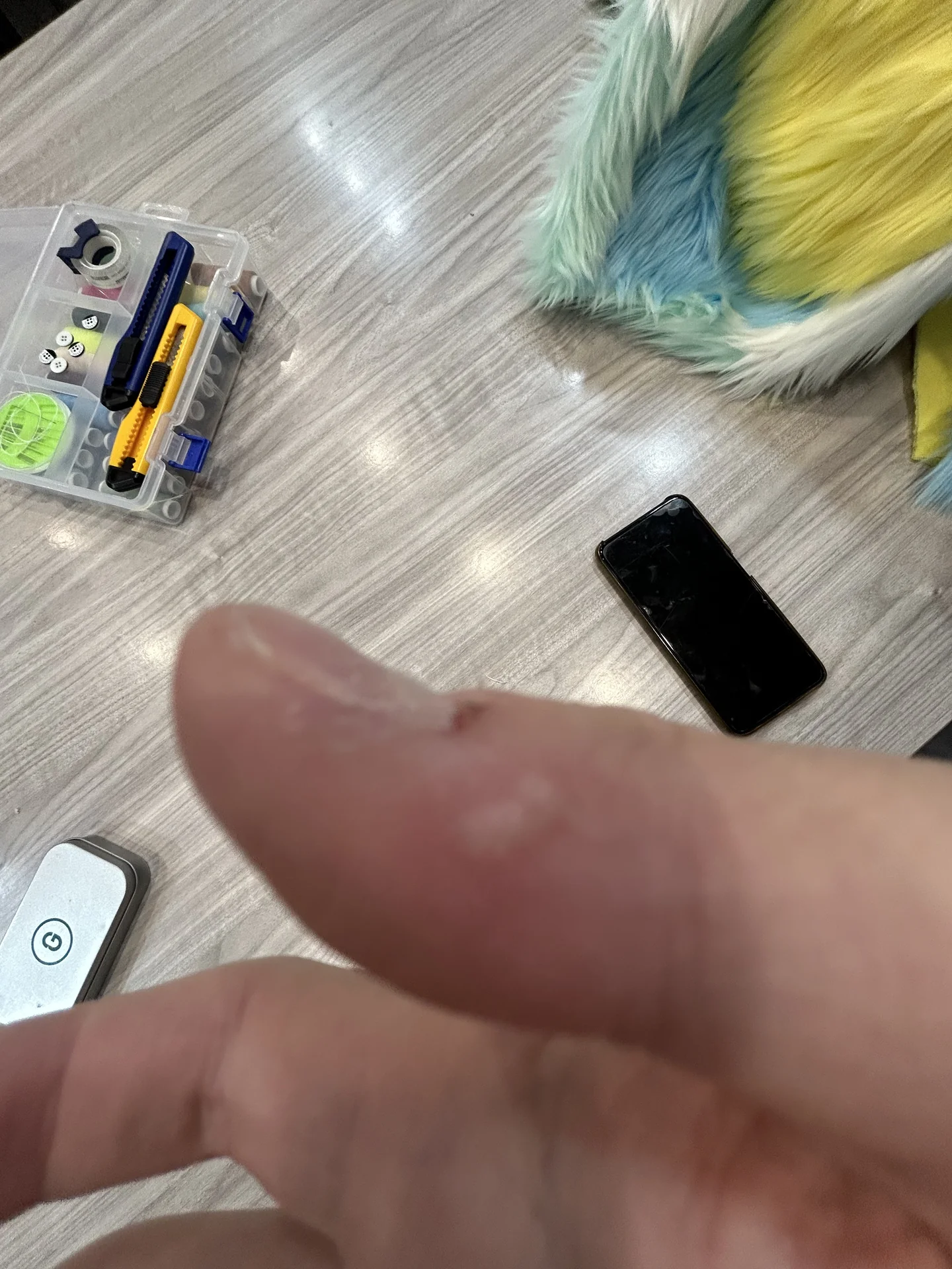 被热熔胶烫出水泡的手指,背景是正在制作的兽装